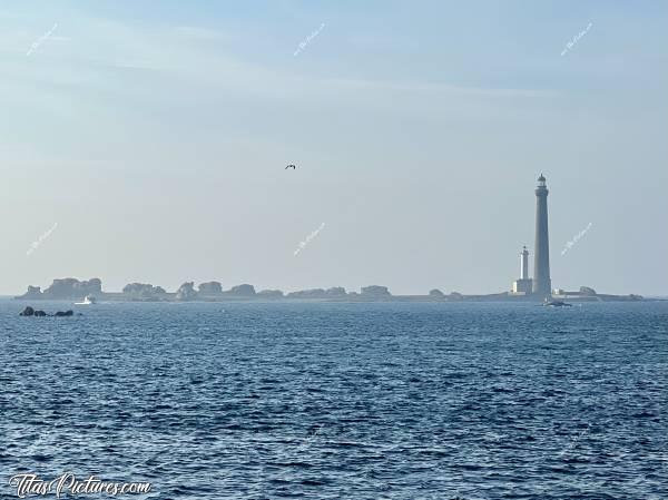 Photo Phare de l’Île Vierge : En face de Plouguerneau, on peut voir le Phare de l’Île Vierge. C’est le phare le plus haut d’Europe et le plus haut du monde en pierre de taille : 82.5 mètres ! 
L’île Vierge s’étend sur près de six hectares et marque la limite orientale entre la Manche et la Mer Celtique. Réputée pour avoir sans doute été un sanctuaire druidique, puis occupée par des moines cordeliers, elle est surtout connue pour son phare. 
Ce phare possède une portée de 27 milles (soit 52 km)… et compte pas moins de 397 marches à gravir pour atteindre son sommet. 
Construit entre 1897 et 1902, il fut électrifié en 1956. A ses côtés, on peut constater un second phare de 33 mètres, qui fut en réalité le premier construit, en 1845, mais dont la portée de 18 milles était nettement insuffisante pour guider les marins à travers la zone bardée de rochers et d’îlots.c, Tita’s Pictures, Phare de l’Île Vierge